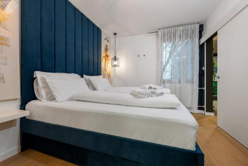 a bedroom with a large bed with a blue headboard at Noble park in Zagreb