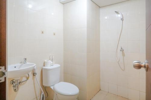 a bathroom with a toilet and a sink and a shower at Bandara City Apartment Near Bandara Soekarno Hatta - Type Studio in Kemplang