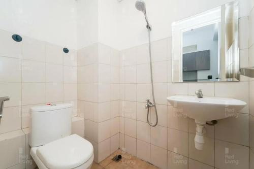 a bathroom with a toilet and a sink at RedLiving Apartemen Riverview Residence - TOHA Room Tower Mahakam in Tegalgede