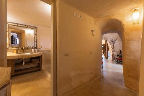 a bathroom with a sink and a mirror at Trulli di Monte Reale by BarbarHouse in Cisternino