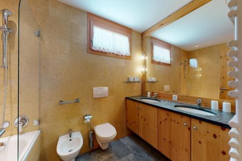 a bathroom with a sink and a toilet and a shower at Apartment Sur Puoz 1A in Samedan