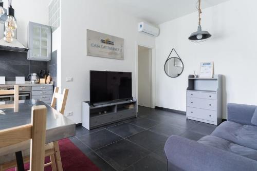 un salon avec un canapé bleu et une télévision dans l'établissement CASA CATTARINETTI - VERONA FIERA, à Vérone