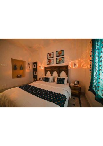 a bedroom with a large white bed with blue curtains at Royal Gharana in Jaisalmer