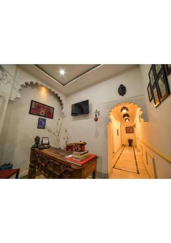 Cette chambre dispose d'un couloir avec une table et une porte. dans l'établissement Royal Gharana, à Jaisalmer