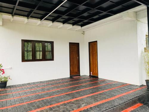 an empty room with white walls and two doors at Sinora Holiday Bungalow in Nuwara Eliya