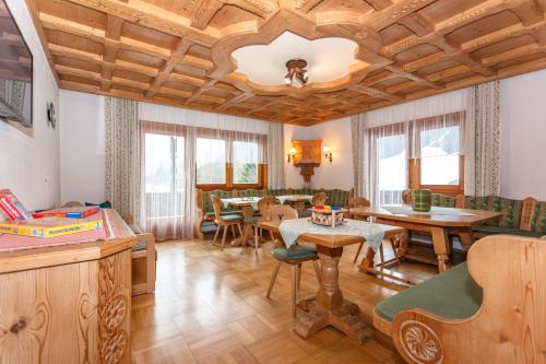 una sala de estar con techos de madera, mesas y sillas en lechner living apartments en Wald im Pinzgau