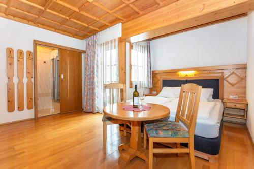a bedroom with a bed and a table with a wine bottle on it at lechner living apartments in Wald im Pinzgau