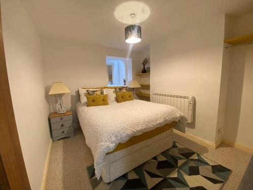 a bedroom with a bed with yellow pillows at Neptune's Nook, Cromer in Cromer