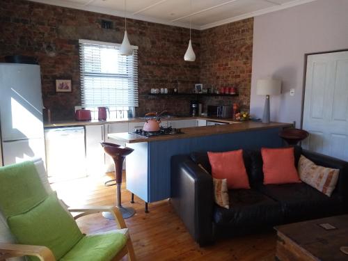 a living room with a couch and a kitchen at Tranquility by the sea in Cape Town