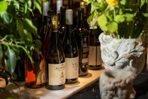 a bunch of bottles of wine on a shelf with plants at Hotel Commercio in Battipaglia
