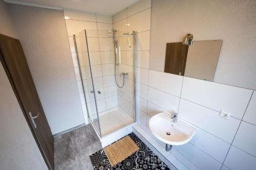 a bathroom with a sink and a shower at Hotel Garni Moers in Moers
