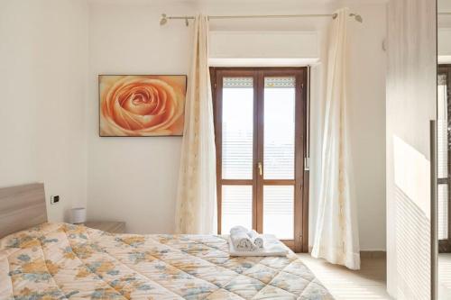 a bedroom with a bed and a large window at Bellissimo Appartamento Centrocittà in Olbia