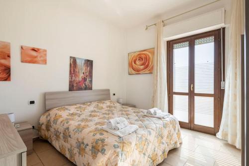a bedroom with a bed and a large window at Dimoras Bellissimo Appartamento Centrocittà in Olbia