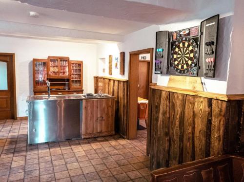 uma cozinha com um bar e um alvo de dardos na parede em Grosses Ferienhaus für bis zu 22 Personen luxuriös ausgestattet mit Aussensauna und HotTub em Dahlem