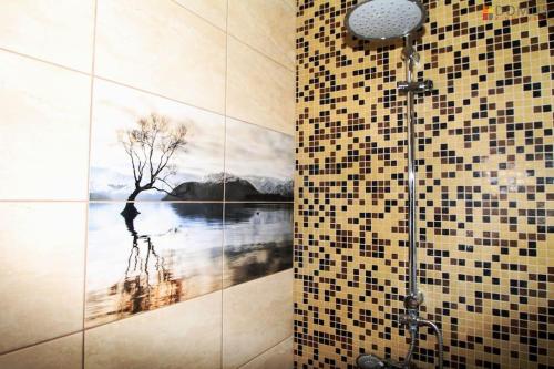 a bathroom with a shower with a painting of a tree at Veski Villa in Pärnu