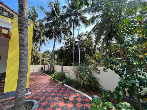 a brick walkway in front of a house with palm trees at PAARK in Nāgercoil