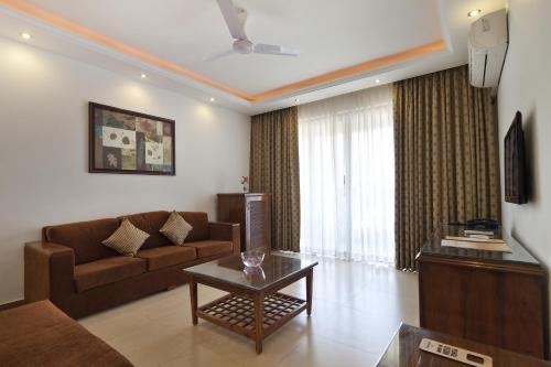 a living room with a couch and a table at De Mandarin Beach Resort Suites & Villas, Candolim in Candolim