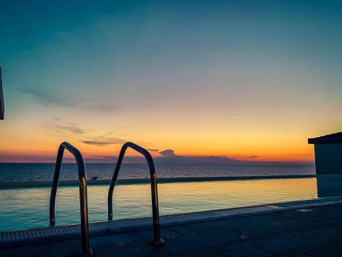 a pair of metal hand rails in front of the ocean at Toscana Charme Resort in Tirrenia