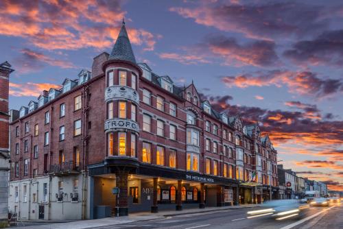 a large building on a city street with a sunset at The Metropole Hotel Cork in Cork
