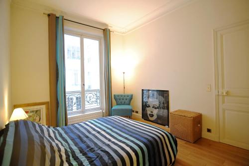 ein Schlafzimmer mit einem Bett und einem Fenster in der Unterkunft Champs Elysees Homestay - AIR CONDITIONING in Paris