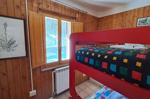 a bedroom with a red bunk bed and a window at Il Covo delle Regine in Abetone
