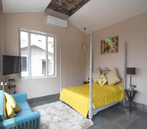 a bedroom with a bed and a couch and a window at 360 South, Khandala in Lonavala