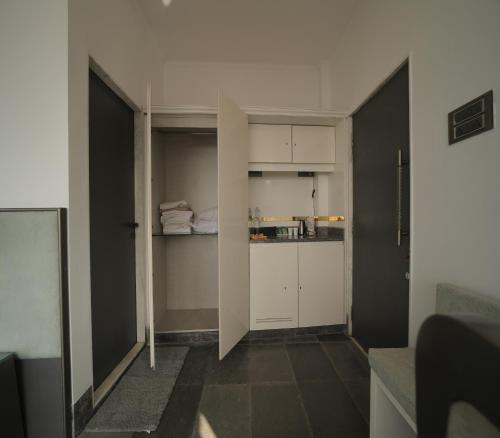 a small kitchen with white cabinets in a room at 360 South, Khandala in Lonavala