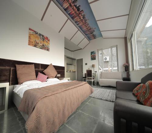 a bedroom with a large bed and a couch at 360 South, Khandala in Lonavala