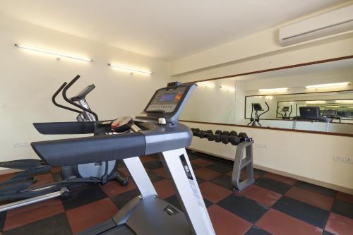 a room with a gym with a treadmill and a mirror at De Mandarin Beach Resort Suites & Villas, Candolim in Candolim