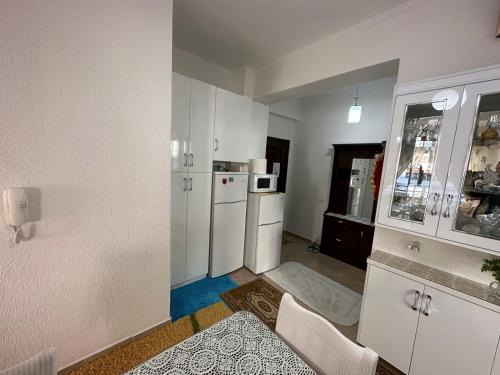a kitchen with white cabinets and white appliances at Taulant in Sarandë