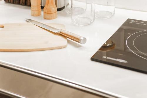a knife sitting on top of a counter next to glasses at Gorgeous Studio Suite w/ King size bed in Antipolo