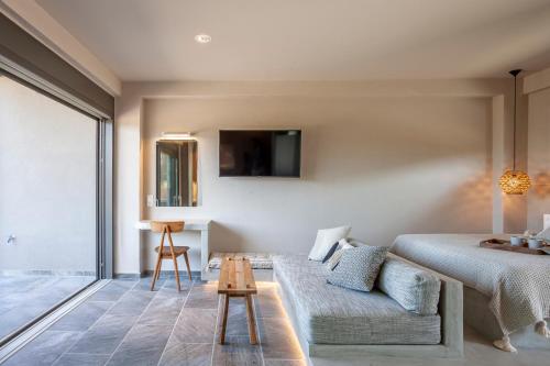 a bedroom with a bed and a couch and a table at Alterra Vita Eco Villas in Neos Marmaras