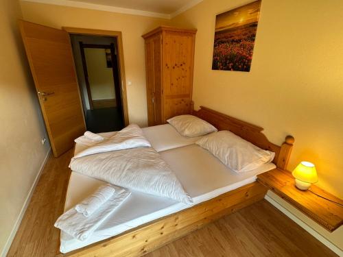 a bedroom with a large bed with white sheets at Moderne Ferienwohnung im Familienparadies MoNi, FeWo 12 in Thiersee