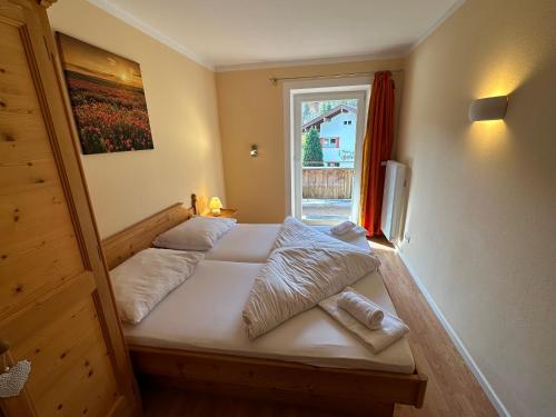 a bed in a room with a window and a bedvisor at Moderne Ferienwohnung im Familienparadies MoNi, FeWo 12 in Thiersee