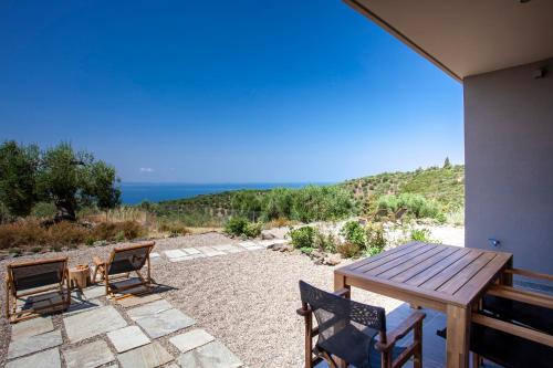 a patio with a table and chairs and the ocean at Alterra Vita Eco Villas in Neos Marmaras