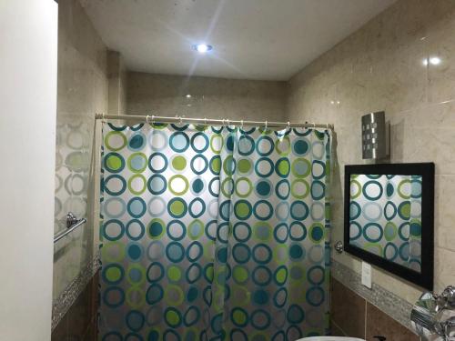 baño con ducha con cortina verde y blanca en Los Robles, en Tepoztlán