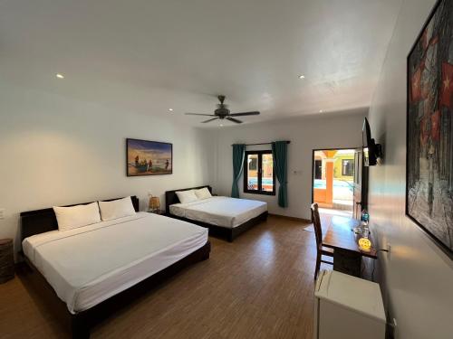 美奈的住宿－Mi Nhon Em Hotel Muine，一间卧室配有两张床、一张桌子和一张沙发