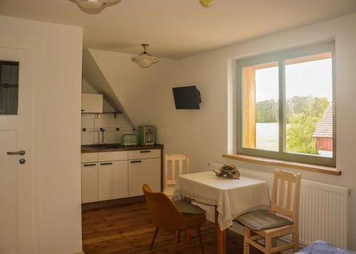 uma cozinha com mesa e cadeiras e uma janela em Wassermühle Förstgen - Eichenzimmer 