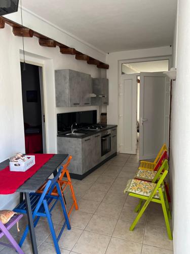 una cocina con sillas coloridas y una mesa con en Vicol8 Casa Vacanze, en Dorgali