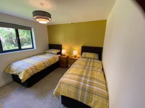 a bedroom with two beds and a surfboard at Cedar Garden Cottage in East Chinnock