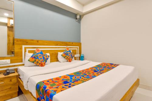 a bedroom with a large bed with colorful pillows at FabExpress Apollo - Nr Odhav Ring Road in Naroda