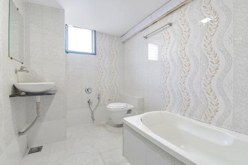 a bathroom with a tub and a toilet and a sink at FabExpress Apollo - Nr Odhav Ring Road in Naroda