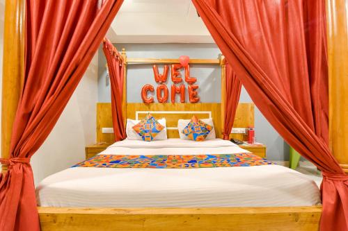 a bedroom with a bed with red curtains at FabExpress Apollo - Nr Odhav Ring Road in Naroda