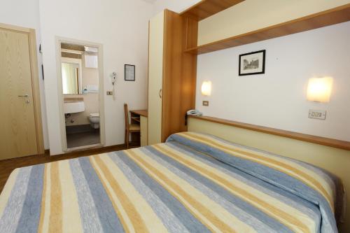 a hotel room with a bed and a bathroom at Hotel Conti in Rimini
