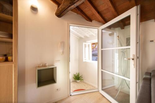 ルッカにあるSibilla Luxury Flat in center townのガラスのスライドドア、テレビが備わる客室です。