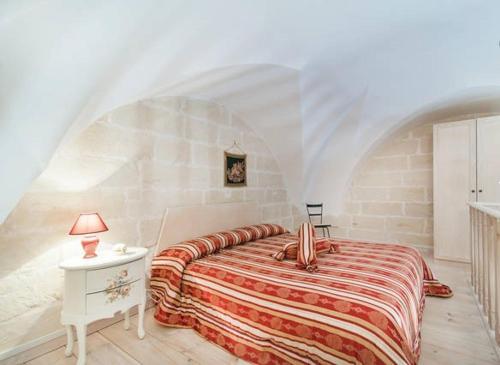 a bedroom with a bed and a table with a lamp at B&B La Casetta in Cavallino di Lecce