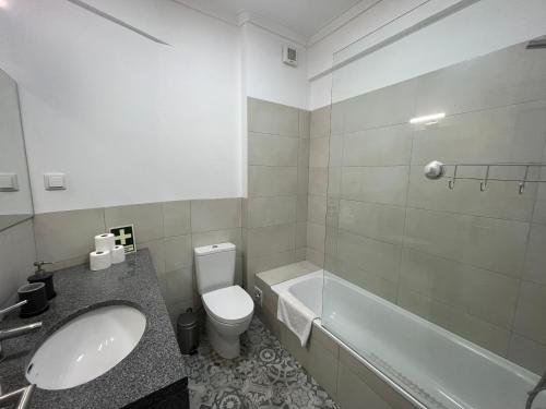 uma casa de banho com um lavatório, um WC e uma banheira em 92 Campolide Apartment by Trip2Portugal em Lisboa