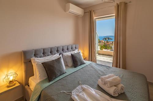 une chambre avec un lit avec une grande fenêtre dans l'établissement Iliana Apartments, à Tolón