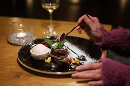 a person sitting at a table with a plate of food at Aparthotel Na Klenici in Mladá Boleslav
