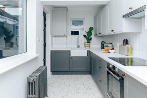a kitchen with white cabinets and a sink at The Neptune in Henley on Thames
